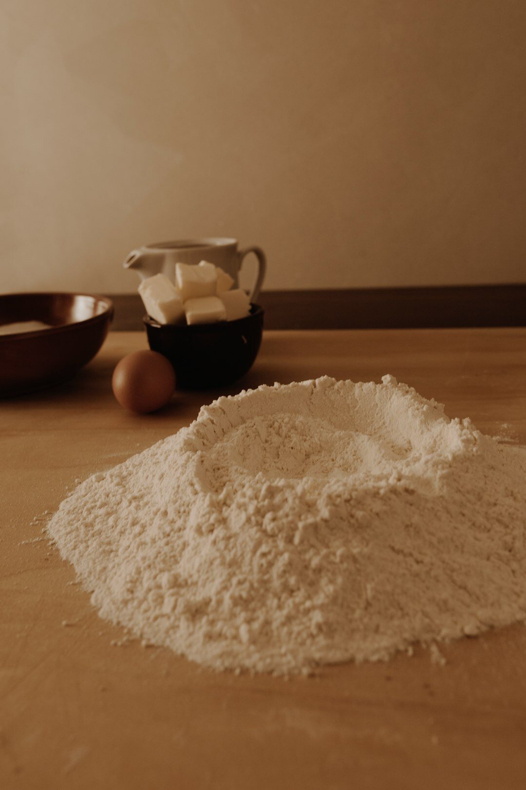Basic cooking ingredients like flour, eggs and butter on a table