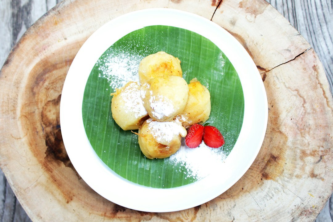Slice of Czech fruit dumplings with butter and sugar on a plate
