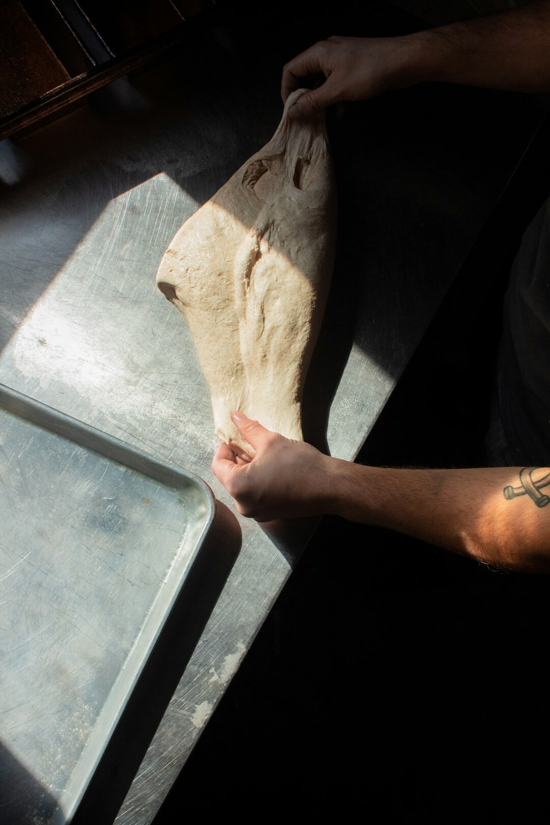 Hands kneading dough on a floured wooden table